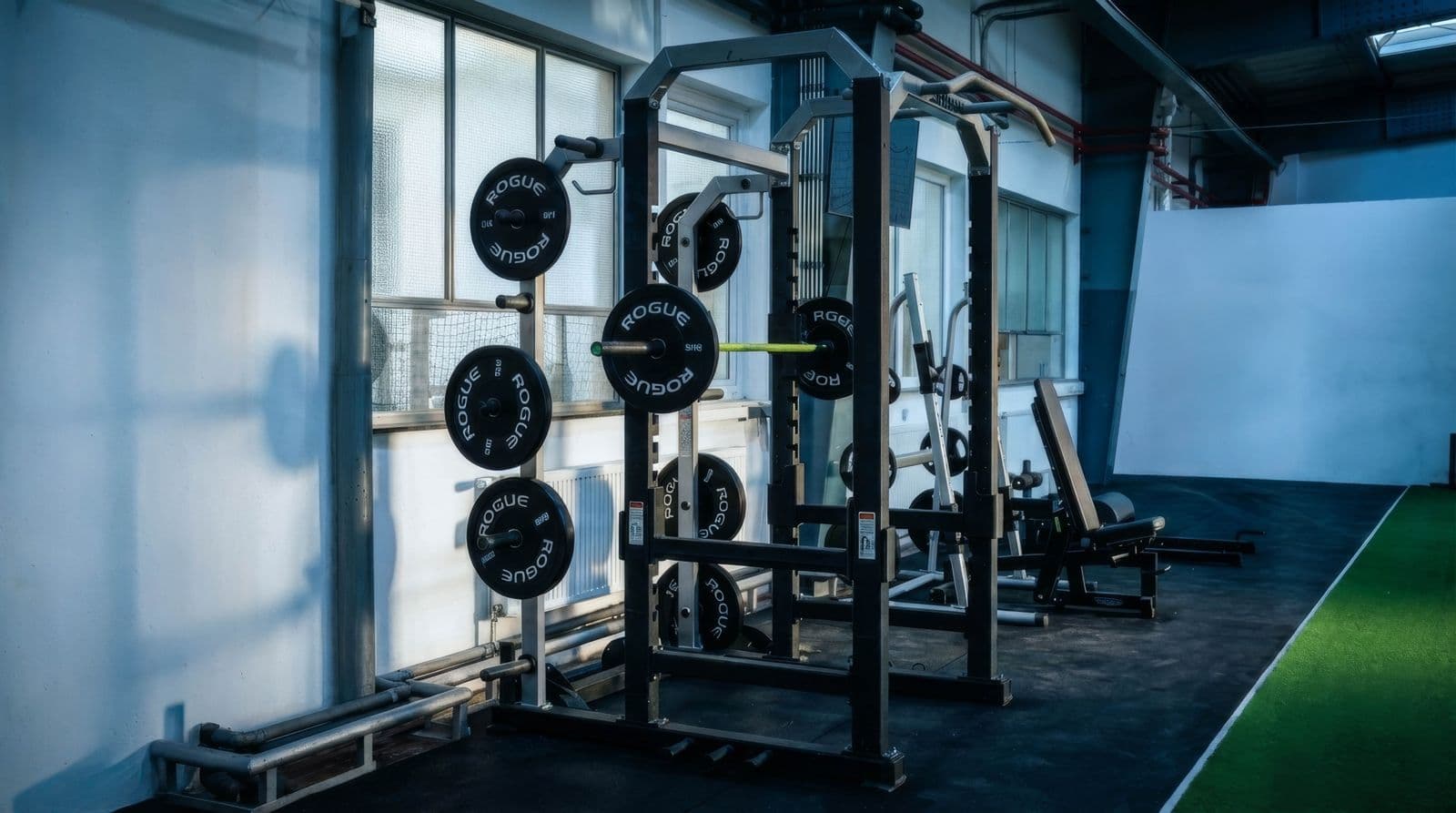 Fitnessbereich der Football Factory mit Power-Rack und Rogue-Hantelscheiben